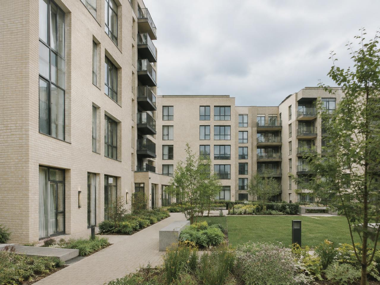 Modern pale-brick apartment development around a landscaped courtyard